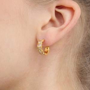 On-ear display of C-shaped 18k gold-plated earrings with rectangular zircon stones