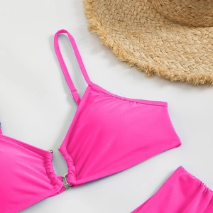Detail of rose pink bikini top featuring adjustable straps and central metal ring connector
