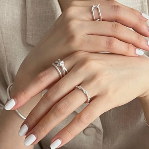 Close-up of minimalist 925 sterling silver knotted and twisted rings on hand