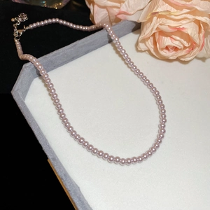 Detail of lavender pearl beaded necklace featuring a metallic lobster clasp and adjustment chain