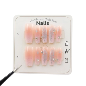 Faux ongles papillon argenté avec dégradé rose et strass présentés sur carte support