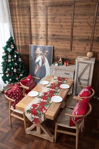 Close-up of festive Christmas table runner and cushions with poinsettia and pine cone motifs