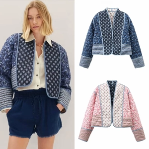 Detail of reversible quilted jacket featuring navy and pink bohemian floral patterns