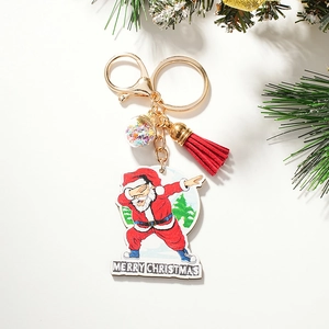 Close-up of dabbing Santa keychain with red tassel and sparkling star-filled ball