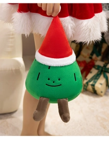 Close-up of cute plush Christmas tree toy with red hat and fuzzy green fabric texture