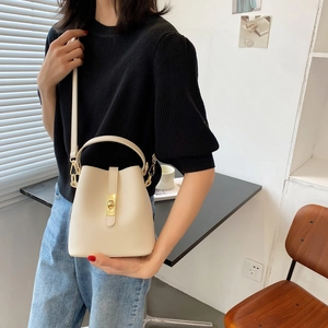 Chic beige bucket bag for women with gold lock and top handle for crossbody style