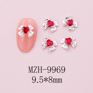 Detailed view of silver bow nail charms with red heart rhinestones measuring 9.5x8mm
