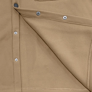 Detail shot of heavy-weight fleece lining and metal snap button on khaki outdoor jacket