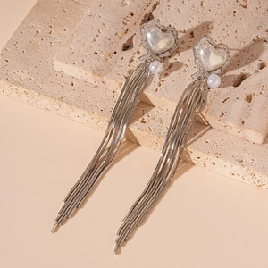 Detail of silver long tassel earrings with heart zircon and elegant faux pearls
