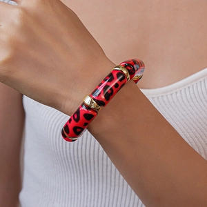 Macro shot of red leopard print acrylic bracelet with polished gold metal spacers