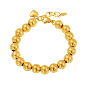 Detail of gold hollow bead bracelet in stainless steel with a heart charm and lobster clasp