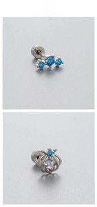 Détail de boucles d'oreilles en acier titane avec étoiles en zircon bleu et sphère ajourée