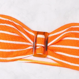 Detail of orange striped smocked bikini top with a decorative amber tortoiseshell buckle