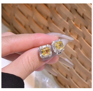 Macro detail of square yellow halo stud earrings in 925 sterling silver with halo stones