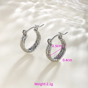 Macro detail of silver textured hoop earrings with dimensions 1.5cm diameter and 0.4cm width
