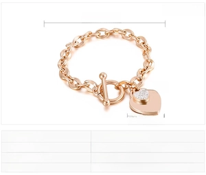 Detailed macro view of heart charm toggle clasp bracelet with white rhinestones in rose gold