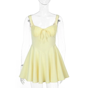 Détail de mini robe jaune en dentelle avec bretelles à nœuds et bustier élégant