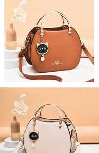 Detail of round shell-shaped handbags in brown and beige with metal ring handles