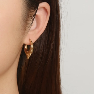 18K gold plated stainless steel hoop earring with spikes on a female model side profile