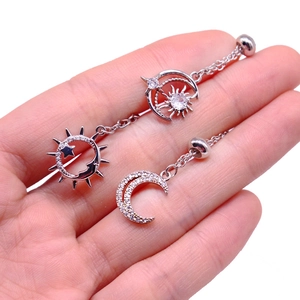 Detailed view of silver nipple rings with sun, moon, and star charms with white rhinestones