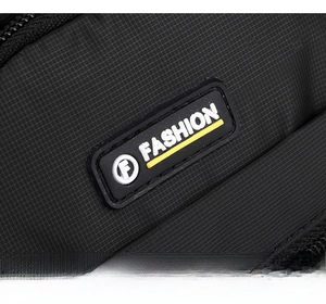 Close-up of black waterproof nylon fabric with fashion rubber logo on the chest bag
