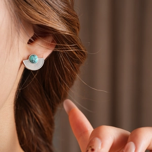 Close-up of vintage fan-shaped titanium steel stud earrings with turquoise on ear