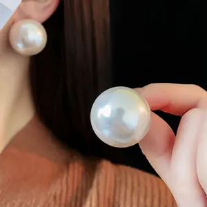 Elegant vintage oversized pearl stud earrings with a lustrous silver pin finish
