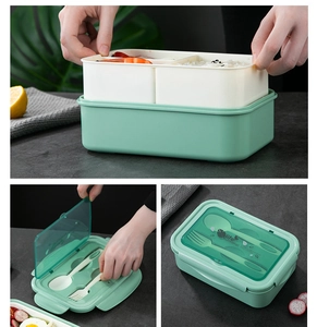 Detail of double-layer green lunch box featuring a cutlery set and secure lid seal
