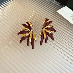 Detail of 18k gold plated leaf earrings with vintage red matte finish and textures