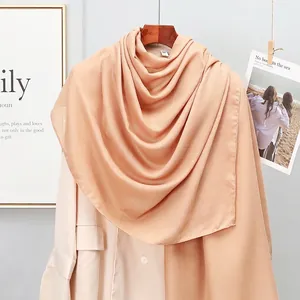 Close-up of lightweight apricot cotton linen scarf draped over a beige blazer