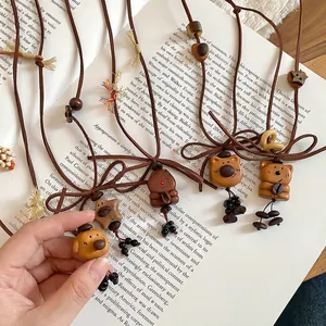 Vintage wooden bear and star pendant necklace set with coffee bean beads on an open book