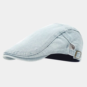 Détail d'une casquette plate en jean bleu clair avec boucle métallique réglable
