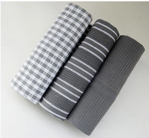 Detail of grey and white waffle weave kitchen towels set in rolled arrangement