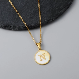 Detailed view of 18K gold plated necklace featuring a round white shell pendant with letter N