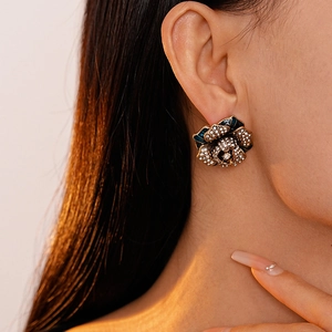 Macro detail of vintage floral earring featuring dark green enamel and shimmering crystals