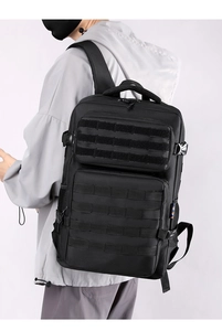 Tactical black backpack with MOLLE system shown on a model during outdoor use