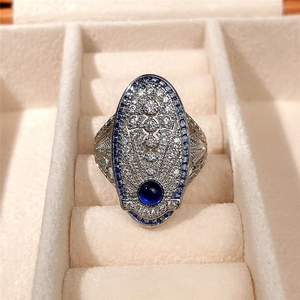 Foto macro de anillo plateado vintage con circón azul real y pavé de diamantes blancos