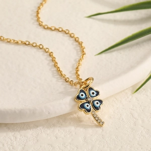 Macro shot of gold clover pendant with blue devil eye enamel and zircon inlay