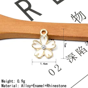 Detailed macro view showing the 1.7cm x 1.4cm dimensions of the cherry blossom charm