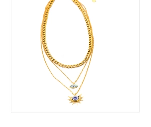 Détail du collier doré à trois rangs avec pendentifs œil bleu et soleil avec cristaux