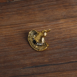 Detail of vintage witch hat brooch with golden woven texture and sparkling rhinestones