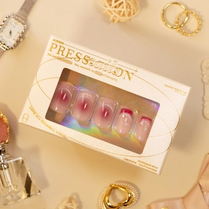 Handmade burgundy press-on nails with cat-eye effect and star patterns in luxury packaging