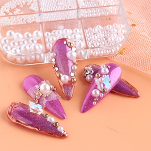 Detail of purple glitter nail art with white pearls, gold beads and butterfly charms