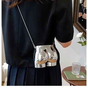 Artistic silver crossbody bag featuring a unique body curve shape and metal chain strap