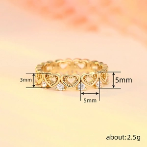 Golden heart-shaped band ring with cubic zirconia stones and delicate openwork design