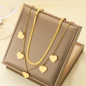 Détail d'un collier double rang doré avec cinq pendentifs cœurs sur boîte en cuir