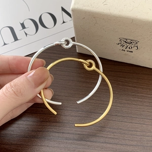 Close-up of gold and silver S925 sterling silver interlocking knot bangles with pavé stones