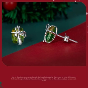 Detailed macro shot of a S925 silver gift box earring with green stone and bow on pine branch