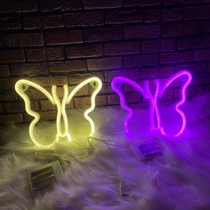 Butterfly LED neon lights in warm white and purple colors on a brick wall background