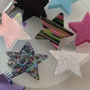 Detailed close-up of various colorful glitter and patterned star-shaped hair claw clips